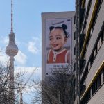 A billboard on the side of a building with a picture of a child on it