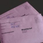 two pink envelopes sitting on top of a table