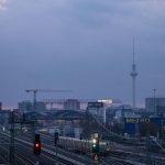 A train traveling down train tracks next to tall buildings