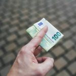 a person holding a piece of money in their hand