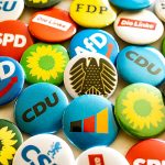 A bunch of different colored buttons on a table