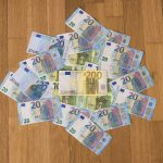 10 and 10 banknotes on brown wooden table