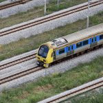 a yellow and blue train traveling down train tracks