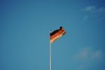 red white and yellow flag on pole under blue sky during daytime