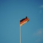 red white and yellow flag on pole under blue sky during daytime