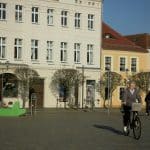 A man riding a bike down a street next to tall buildings