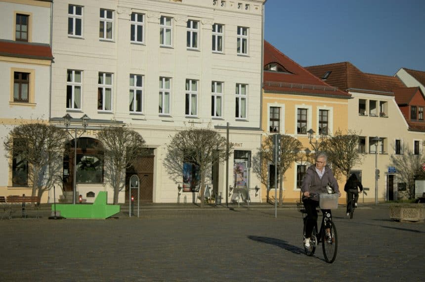 A man riding a bike down a street next to tall buildings