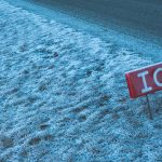 A red ice sign sitting on the side of a road