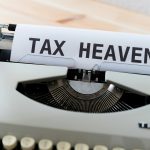 a close up of a typewriter with a tax heaven sign on it
