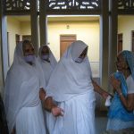 woman in white hijab standing beside man in blue dress shirt