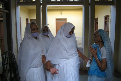 woman in white hijab standing beside man in blue dress shirt