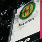 A close up of a street sign with trees in the background