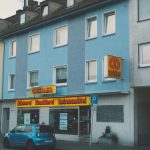 a blue car parked in front of a building