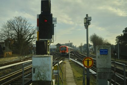 a train traveling down train tracks next to a traffic light