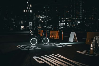 A cyclist rides through a city street at night.