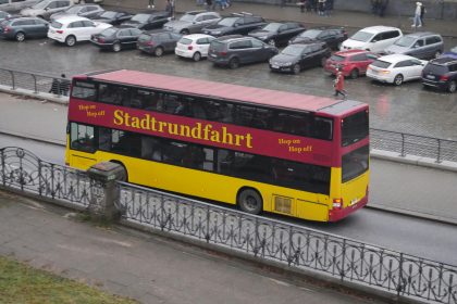 a yellow and red double decker bus driving down a street