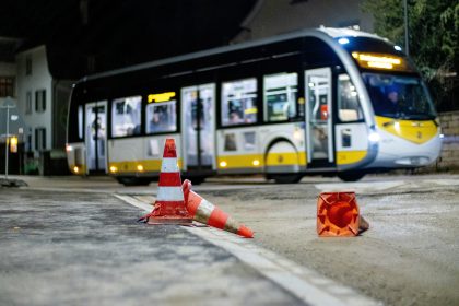 a bus driving down a street next to traffic cones