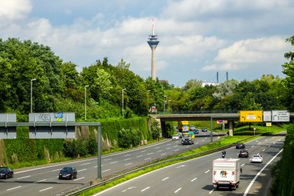 Cars driving on a highway with a tower in background