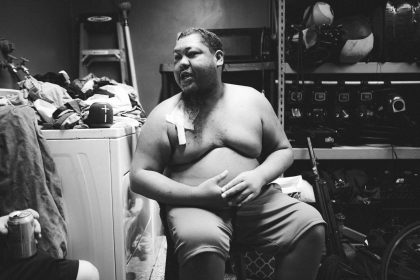 a fat man sitting on top of a washing machine