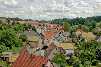 A picturesque village nestled among green trees and hills.