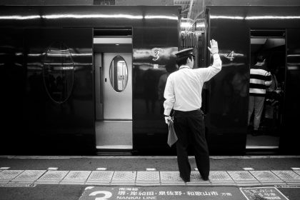Train conductor waving goodbye at station