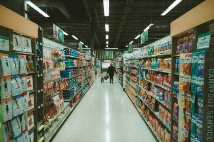 a person walking down a aisle in a grocery store