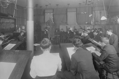 a group of men sitting at desks in a room