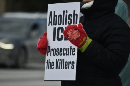 Person holding sign that says abolish ice prosecute the killers