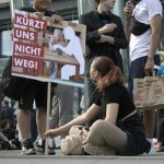 a woman sitting on the ground next to a sign