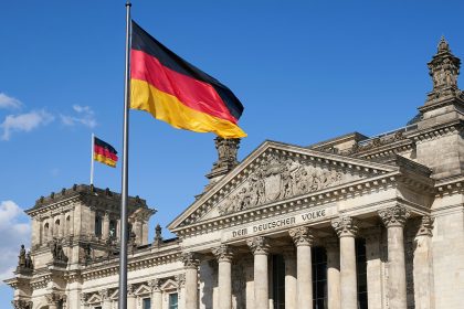 a german flag flying in front of a building