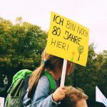 a woman holding a sign that says i am sorry