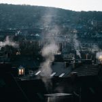 smoke coming out of a chimney on top of a building