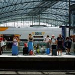 a group of people standing on a platform next to a train