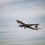 white airliner plane flying at sky