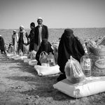 a group of people standing around bags of sand